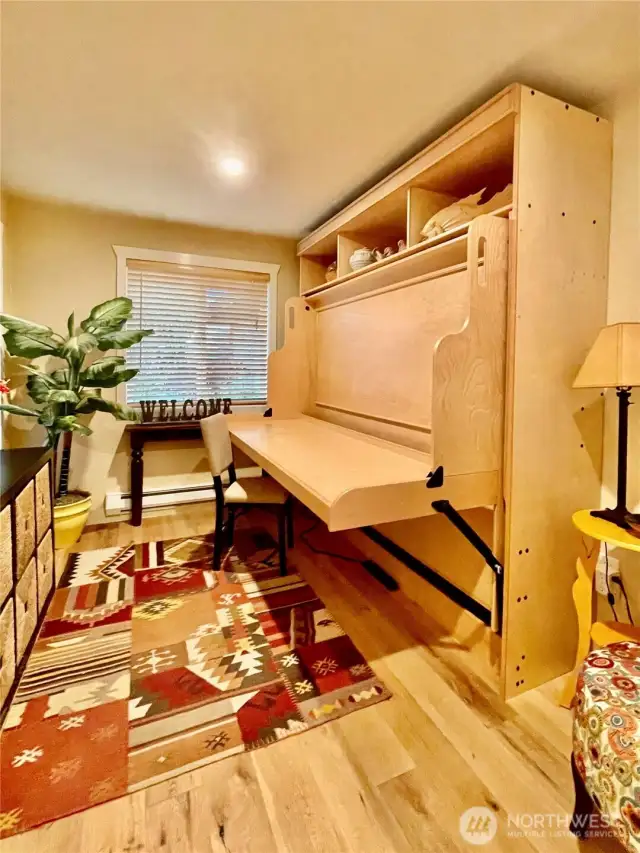 second bedroom featuring a custom-built Murphy bed with integrated shelving and a fold-down desk, this space effortlessly transforms to suit your needs—perfect for remote work during the day and welcoming guests at night.