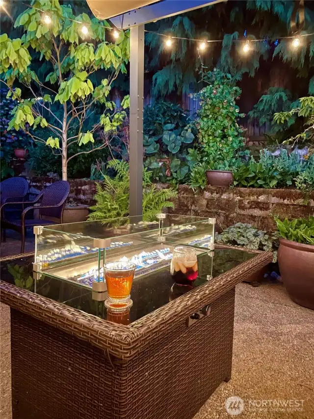 This enchanting backyard patio offers the perfect setting for evening relaxation