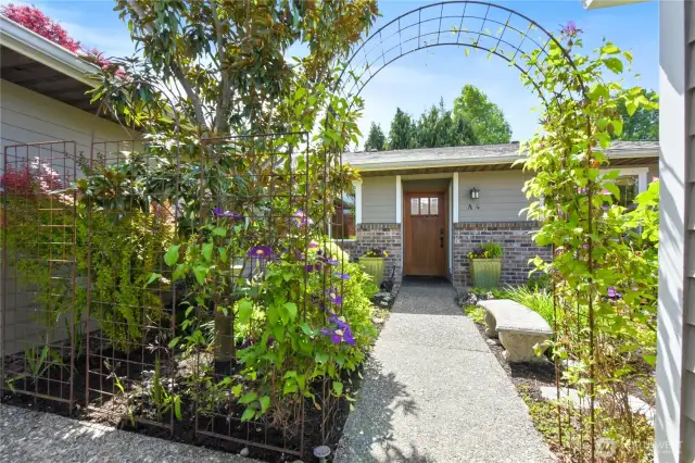 A beautifully landscaped walkway leads directly from the carport to the home’s welcoming front entrancel.