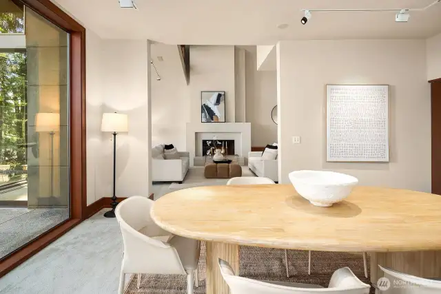 The light-filled dining area offers a warm view of the fireplace, adding ambiance to every meal.