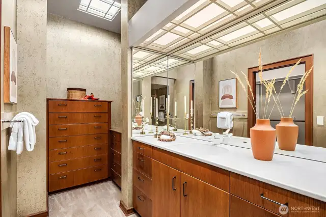 The primary suite includes an expansive bathroom with a step-in shower, dual vanities, two built-in dresser storage areas, and two walk-in closets—all crafted from high-quality wood.