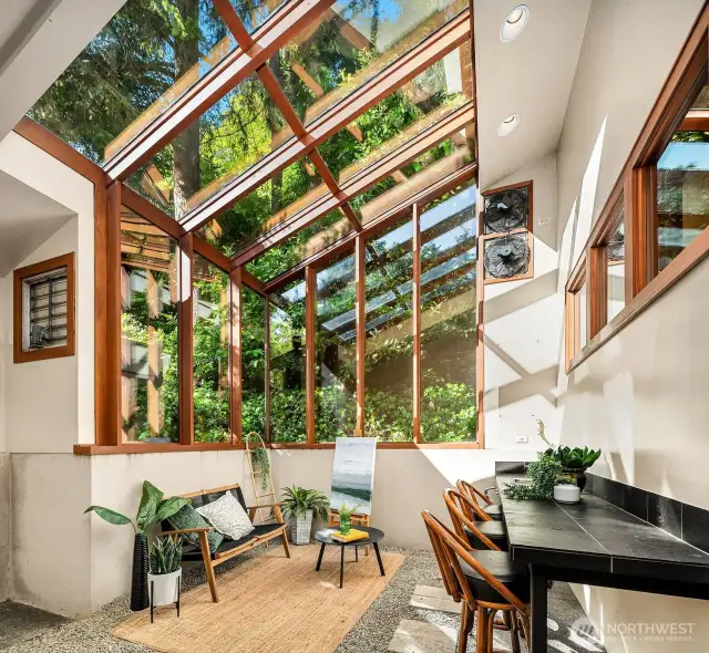 The light-filled solarium is full of charm, with access through three doors—connecting to the adjacent bedroom, the library, and the backyard.
