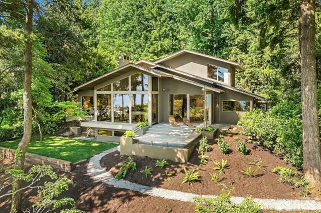 This custom-built home is a light-filled oasis, with floor-to-ceiling west-facing windows and an exceptionally private setting.