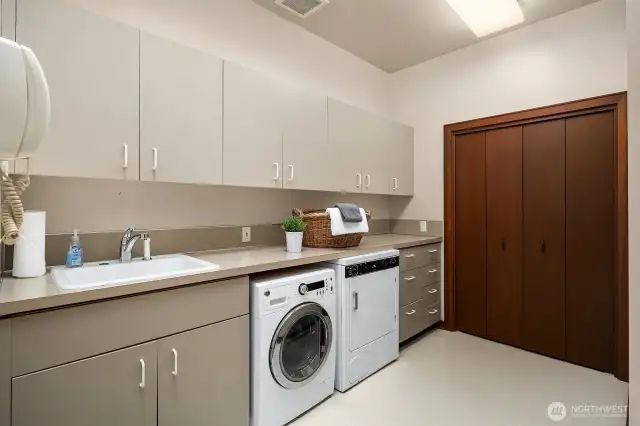 The generous laundry room features a utility sink, abundant storage, and ample space for sorting, folding, and organizing.