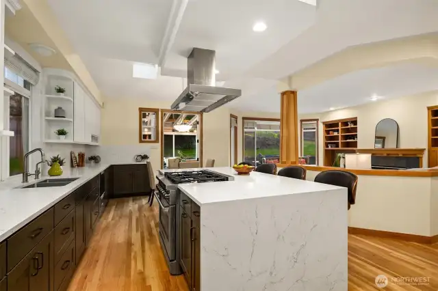 Updated kitchen featuring a sleek waterfall granite island and modern finishes