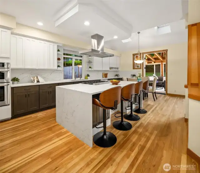 Updated kitchen featuring a sleek waterfall granite island and modern finishes