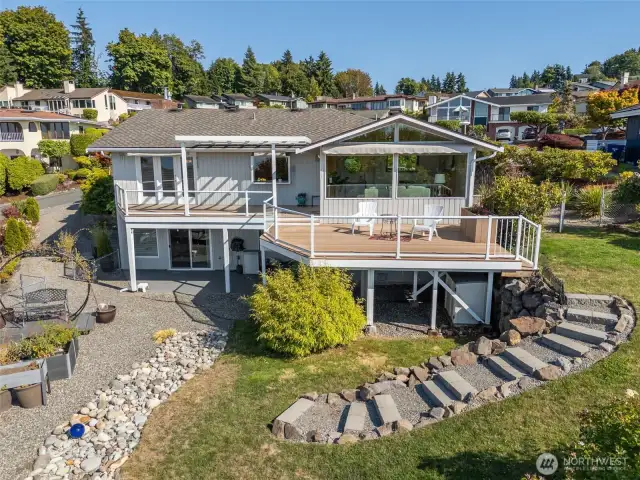 Expansive deck with glass railing for unobstructed views up top, and covered patio below.