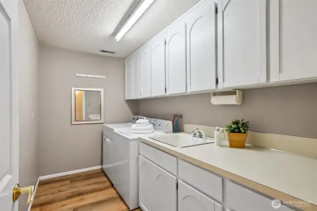 Large & practical laundry room! Loads of cabinets + sink!
