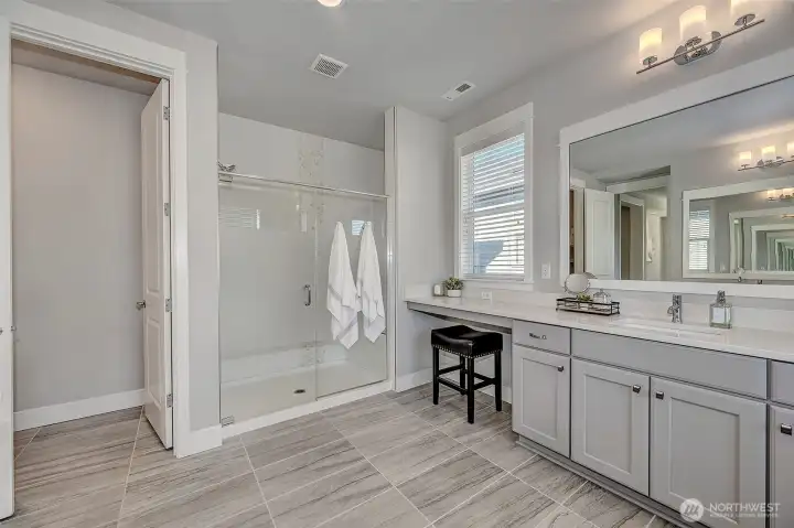 5-piece primary ensuite with an extra long countertop with sitting area