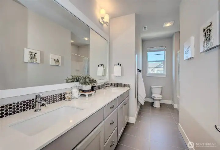 Full bathroom with double sinks & tub shower
