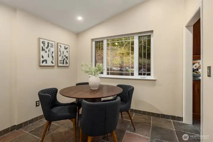 Breakfast nook adjoins kitchen and family room, with beautiful windows looking out on nature.