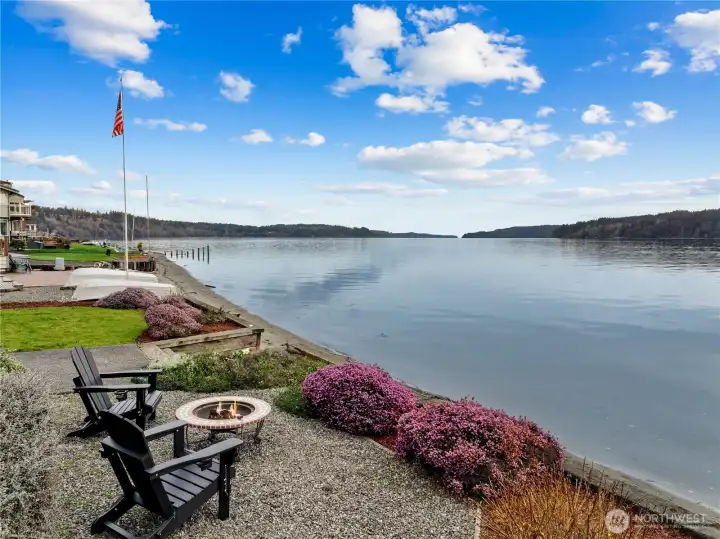 Private waterfront with firepit seating, offering sweeping views and a tranquil outdoor experience.