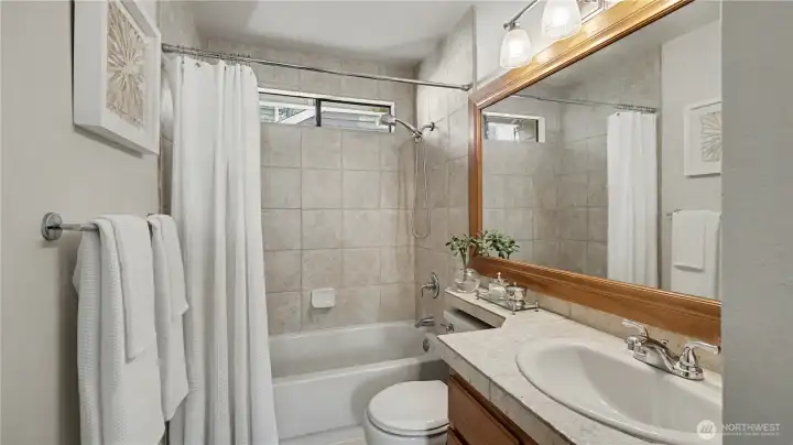 The full hall bath has tile floors, countertops and bath surround.