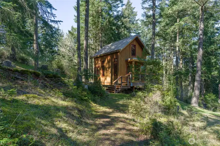 Follow the woodland trail to a fully separate guest cabin with its own wood stove, window bench, and full bath.