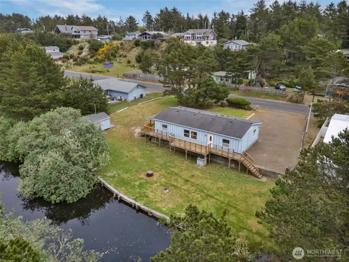 Aerial view of the property showing canal frontage, spacious yard, and surrounding neighborhood setting.