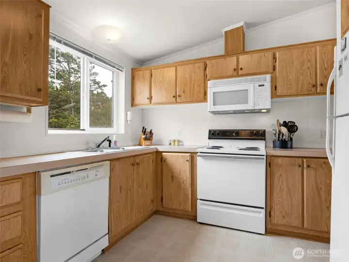 Kitchen featuring updated appliances, generous counter space, and canal-facing window views.