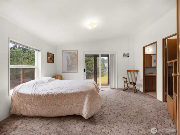 Primary bedroom with generous space, large windows, and private exterior access.
