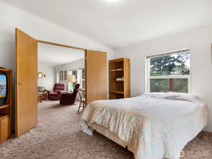 Primary bedroom featuring natural light and views of the surrounding property.