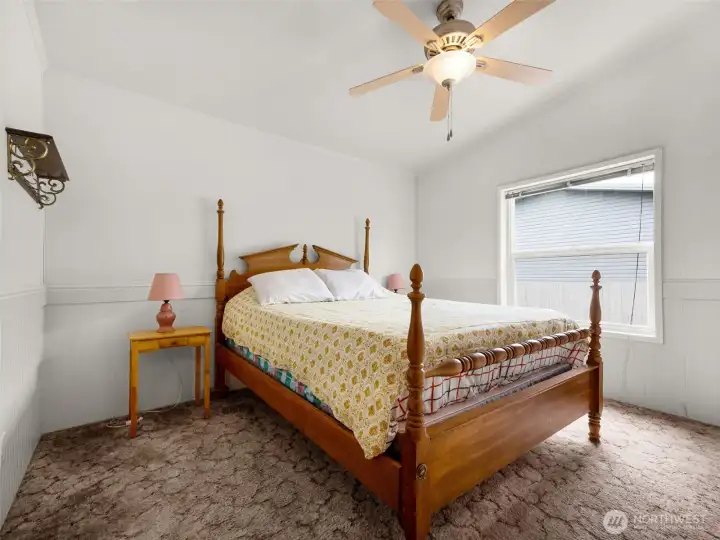 third bedroom with ceiling fan, large window, and comfortable layout.