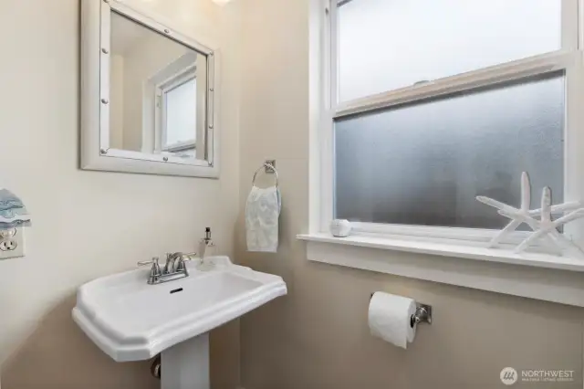 The powder room is just off the hallway near the kitchen.