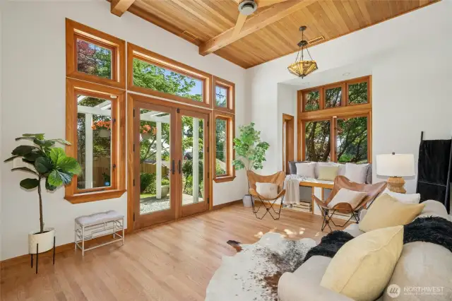 French doors lead to backyard deck with a trellis for just the right amount of shade