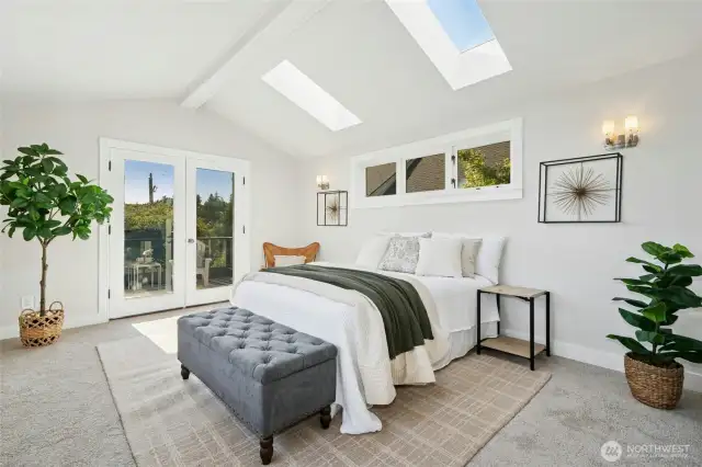Skylights accent this lovely primary upstairs suite, with french doors leading to a spacious balcony with views of Puget Sound