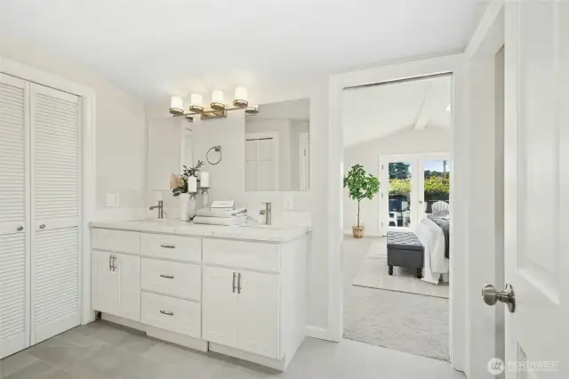 Full primary bathroom with primary bedroom beyond. Walk in closet to the left