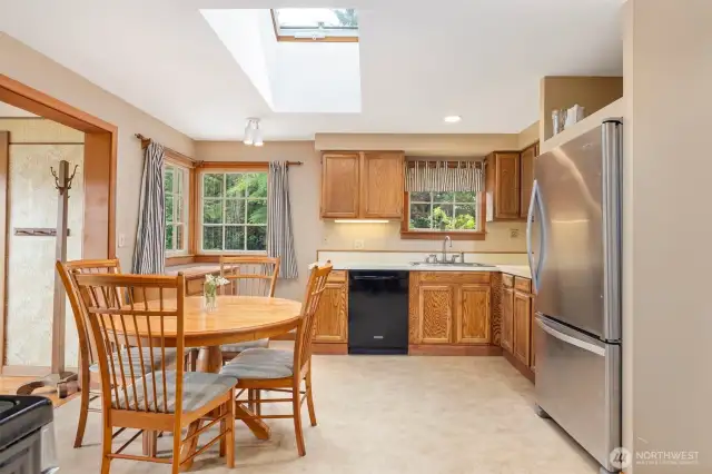 Another view showing the spacious kitchen with the operable skylight above the dining table.