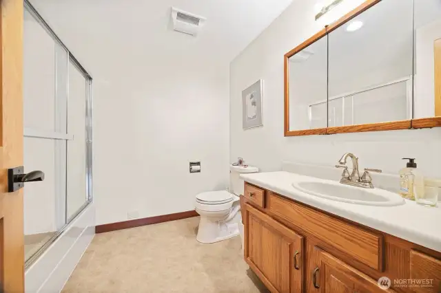 The full bath is across the hall from the living room and beside the 3rd bedroom.
