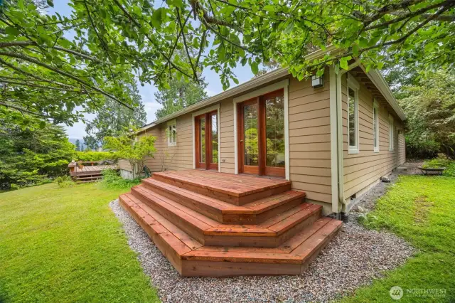 The deck with 3 steps down is just off the primary bedroom and such a perfect place to take in nature any time of the day. Apparently, the deer come onto the deck to reach the apples before they fall from the tree.