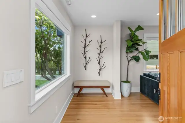 A warm and welcoming entry framed by picture windows and glistening hardwoods sets the tone for refined living.