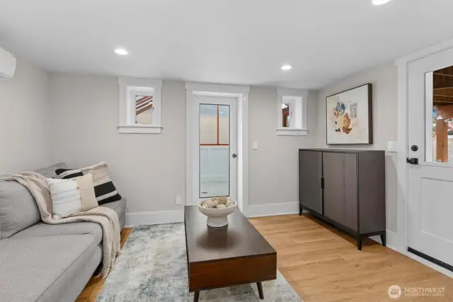 Lower-level bonus room perfect for movie nights, with direct access to the private backyard and adjacent solarium/greenhouse.