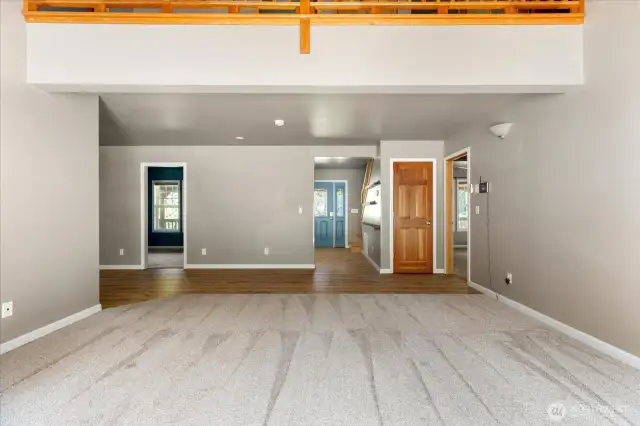 In living room looking towards office on left and front door straight ahead. Storage closet and primary bedroom on right