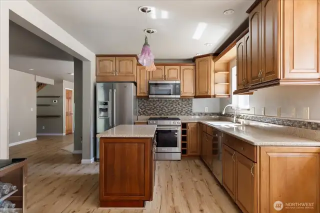 Custom kitchen with stainless steel appliances  including gas stove and island