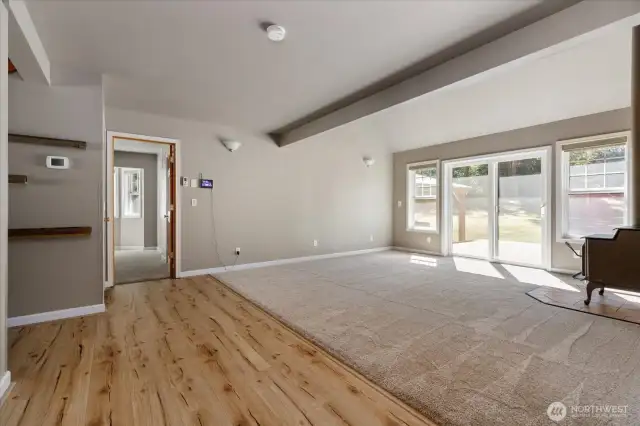 View from dining room towards living room and primary bedroom entry