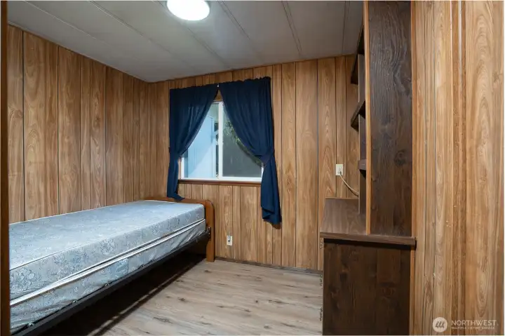 Cozy bedroom with natural light and built-in shelving, offering functional storage and flexible use of space. Ideal as a guest room, office, or additional sleeping area.