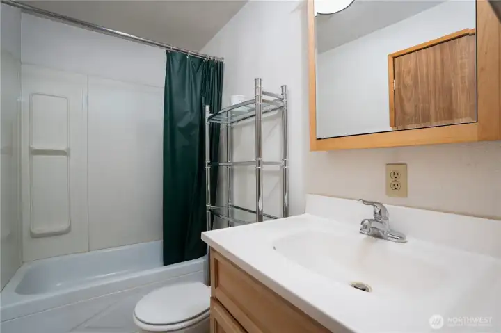Clean and functional guest bathroom featuring a tub/shower combination and practical layout. Ample counter space and storage make it well-suited for everyday use.