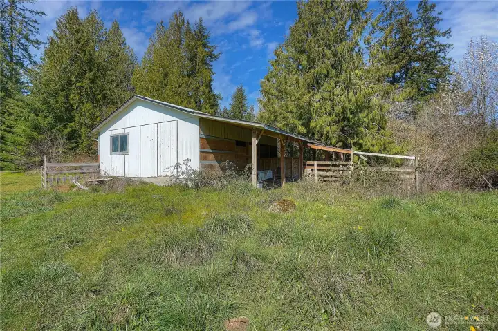 Barn and covered livestock area ready for animals, offering shelter and fenced space for easy care and management. Ideal setup for horses, goats, or hobby farming with room to expand.