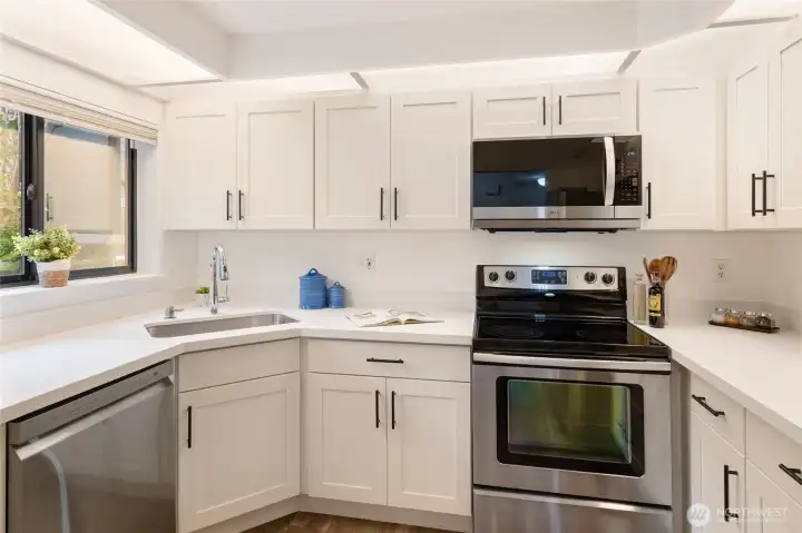 The kitchen has been stylishly remodeled with quartz countertops and new cabinets.