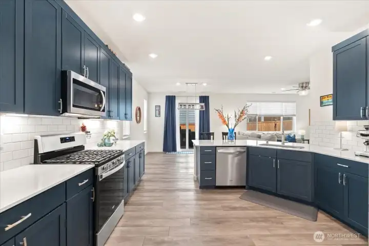 Open-concept design with quartz counters and deep blue cabinetry. Open-concept design with quartz counters and deep blue cabinetry.