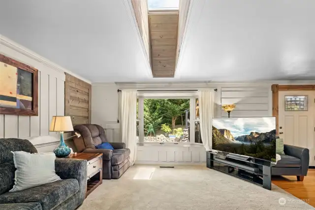 Board and batten walls with shiplap accents. Tongue and grove knotty pine wraps the alcove up to the skylight, letting natural lighting in from above. Bonus: skylight has adjustable blinds to open and close as you please. Bay window with window seat looks out into back yard.