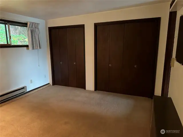 Primary bedroom dual closets one is set up for laundry .