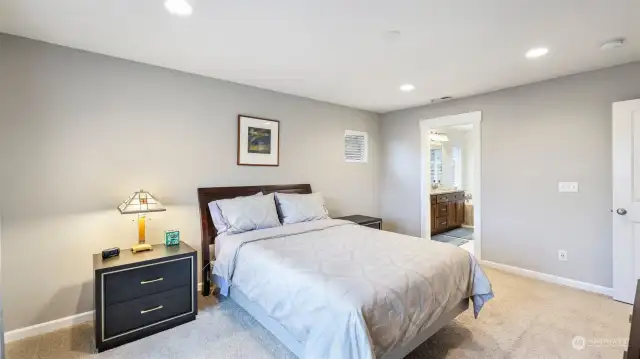 This cozy bedroom with white walls is perfect for relaxation and features convenient access to the bathroom.