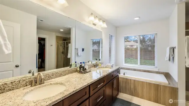 This view showcases the bathroom with window walls, offering a glimpse of the outdoor backyard of the house.