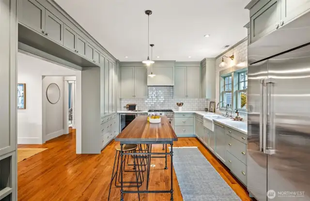 Stunning kitchen features 36" range, oversize refrigerator, wine fridge, an abundance of storage, and large, custom walnut island.