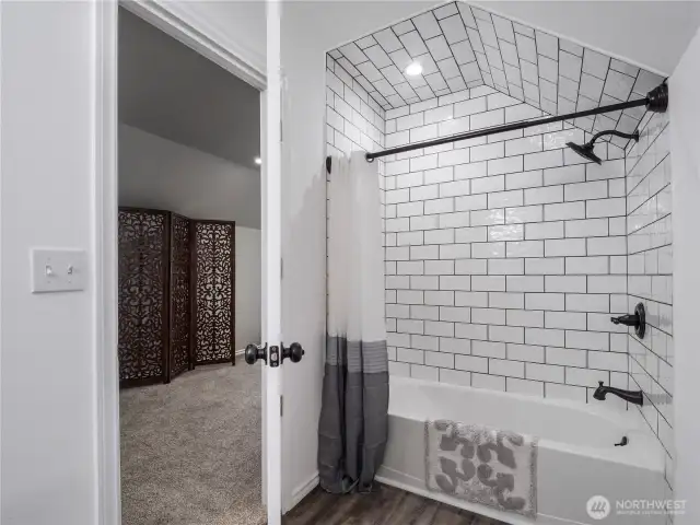 Full bathroom was recently remodeled and features luxury laminate flooring, subway tile, soaker tub, and vanity with a stone countertop.
