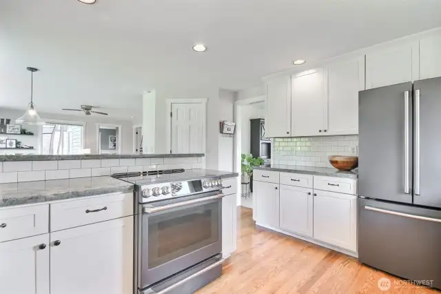 Crisp white shaker cabinetry, classic subway tile backsplash, and sleek granite countertops create a clean, timeless aesthetic.