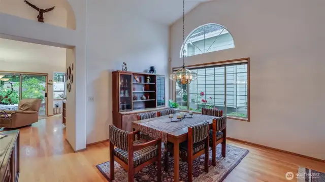 The dining room has the same tall beautiful soaring ceiling with large well placed windows.