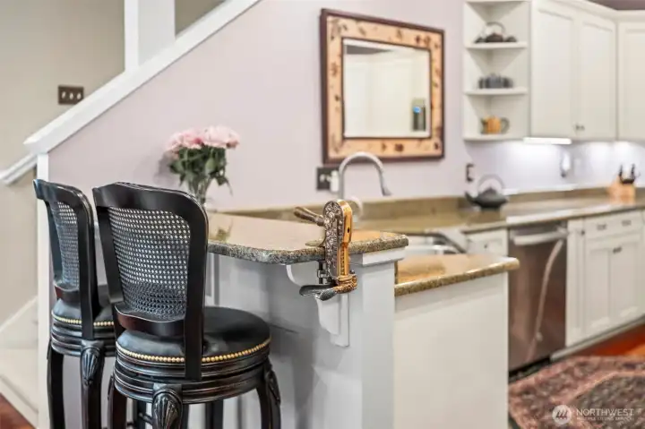 The breakfast bar and granite countertops are accompanied by a vintage bottle opener.