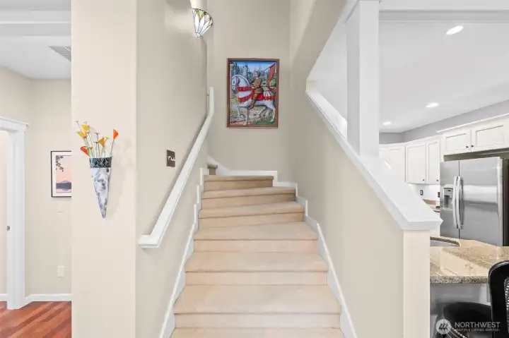 An inviting staircase to the 2nd level has two decorative wall sconse light fixtures.
